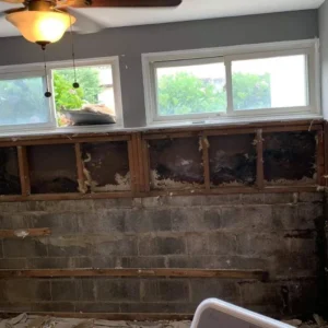 Before photo of an exterior wall with water damaged drywall removed in Ocala, FL