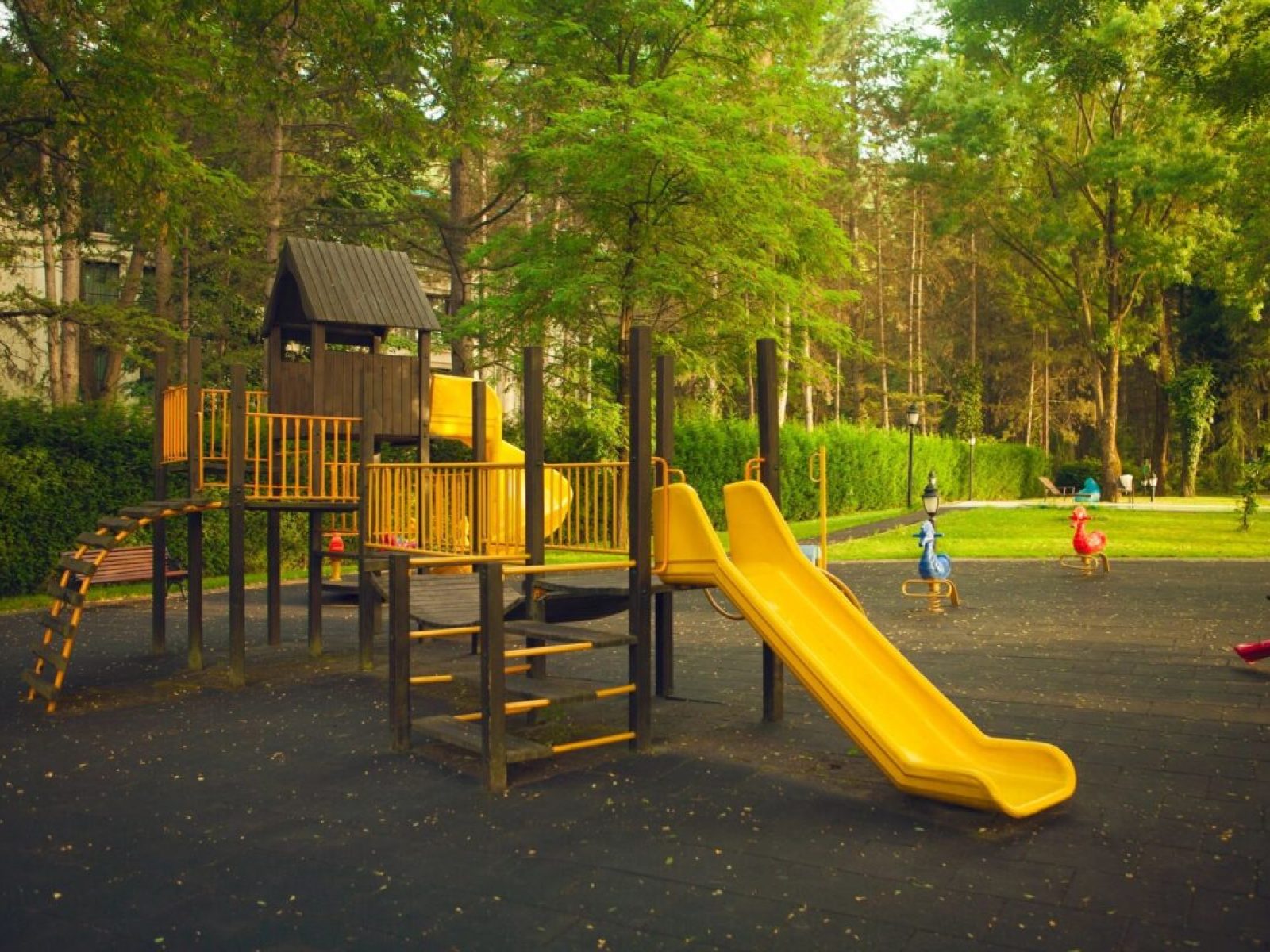 Freshly assembled yellow playground set in a shaded park area with children playing nearby in Marion County, Florida.
